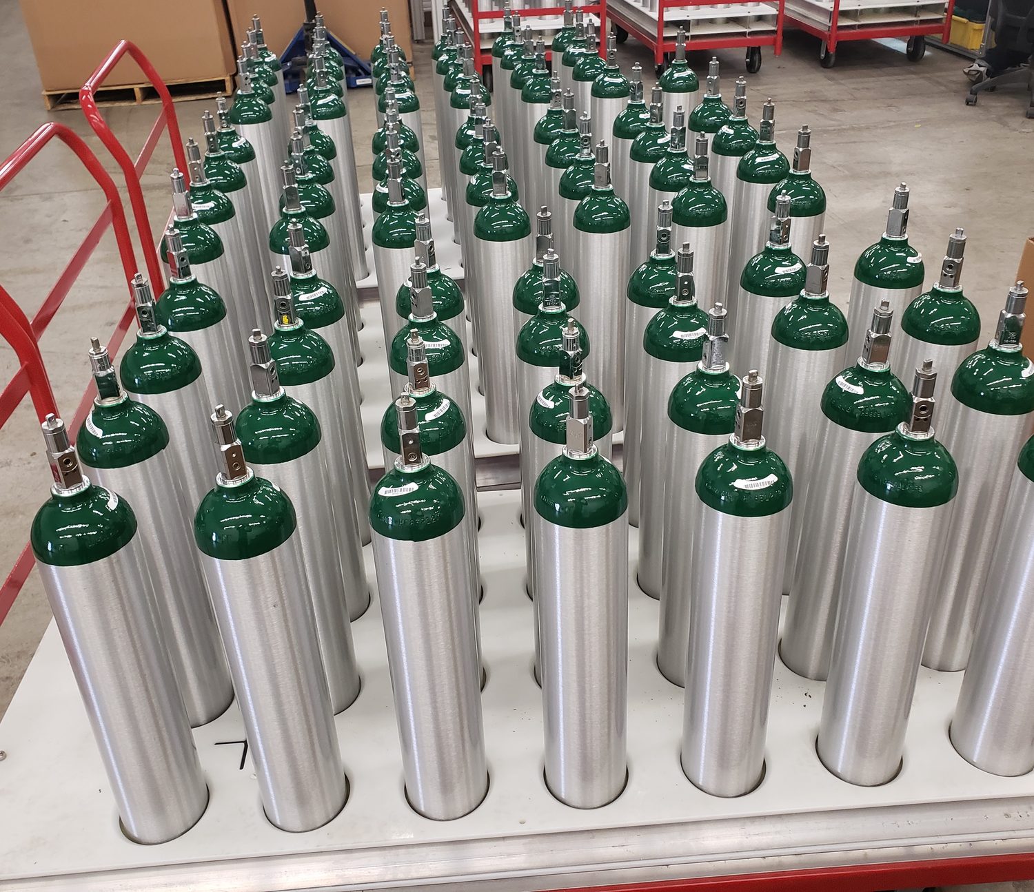 Medical oxygen cylinders racked on a shop cart, ready to ship